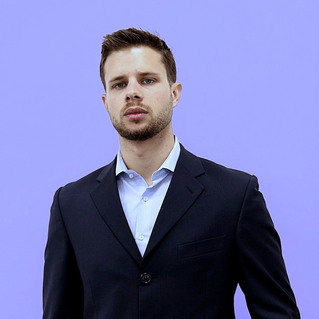 Davide Giacomel, in a dark suit and light blue shirt